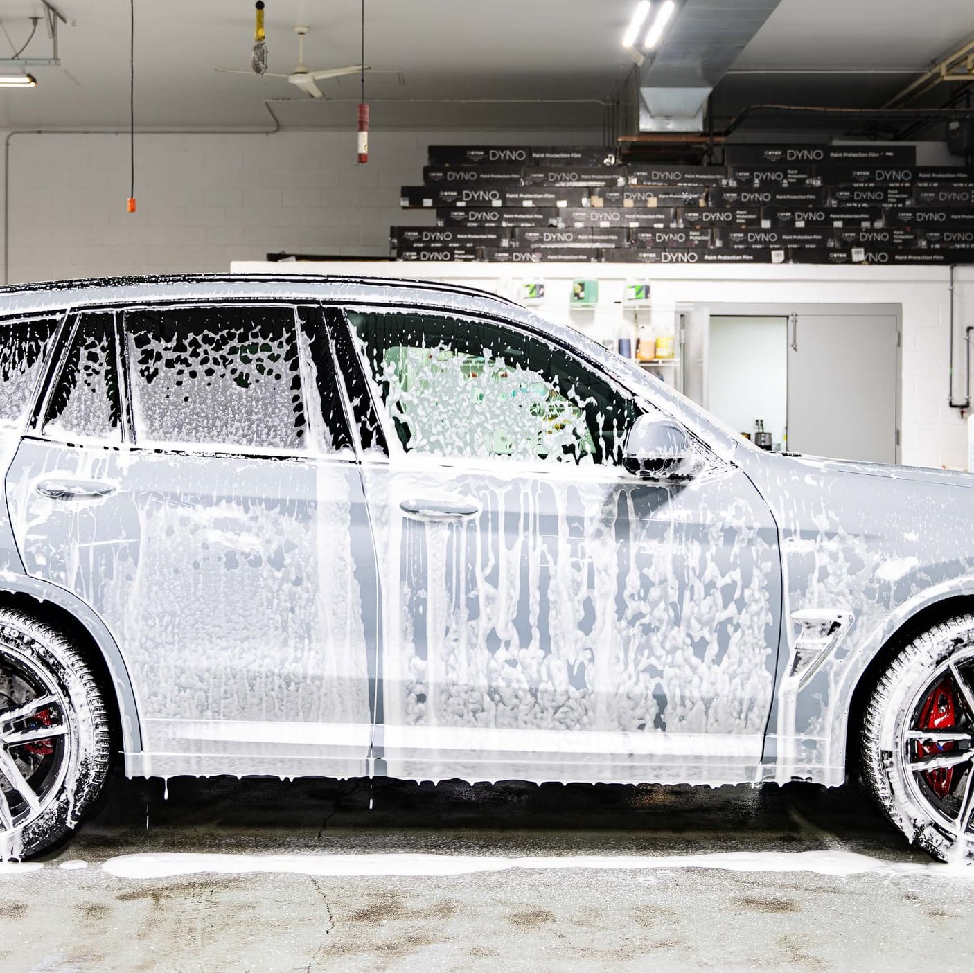BMW covered in snow foam during an exterior detail.