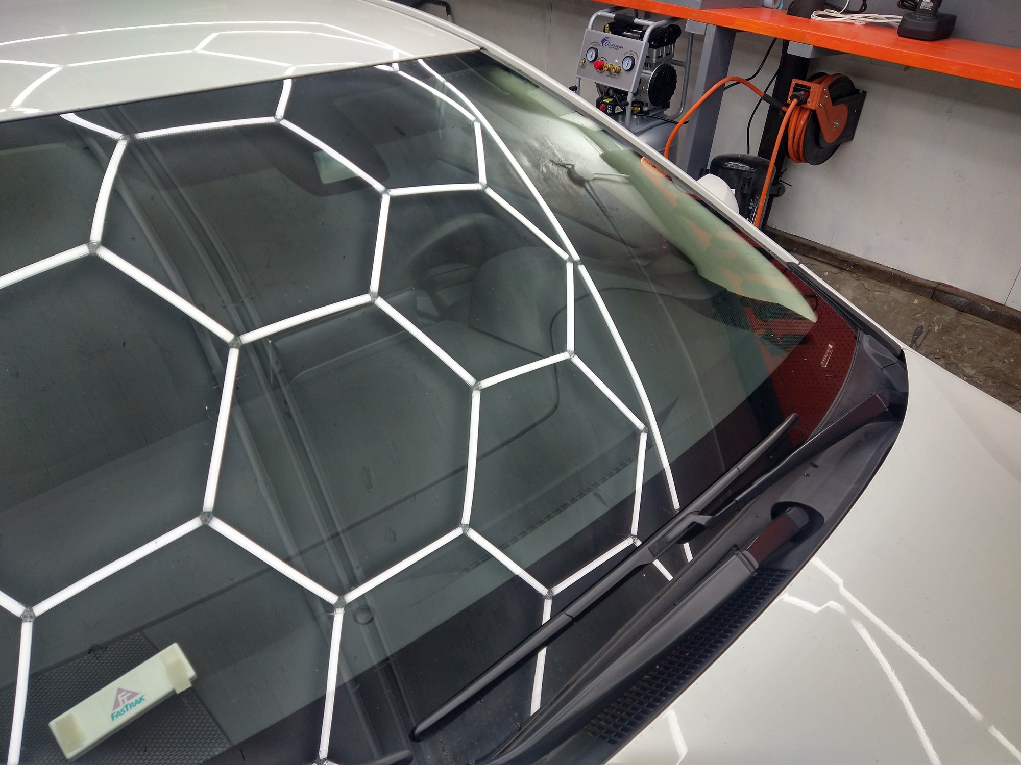 Water beading tightly on a panel after ceramic-coating application.