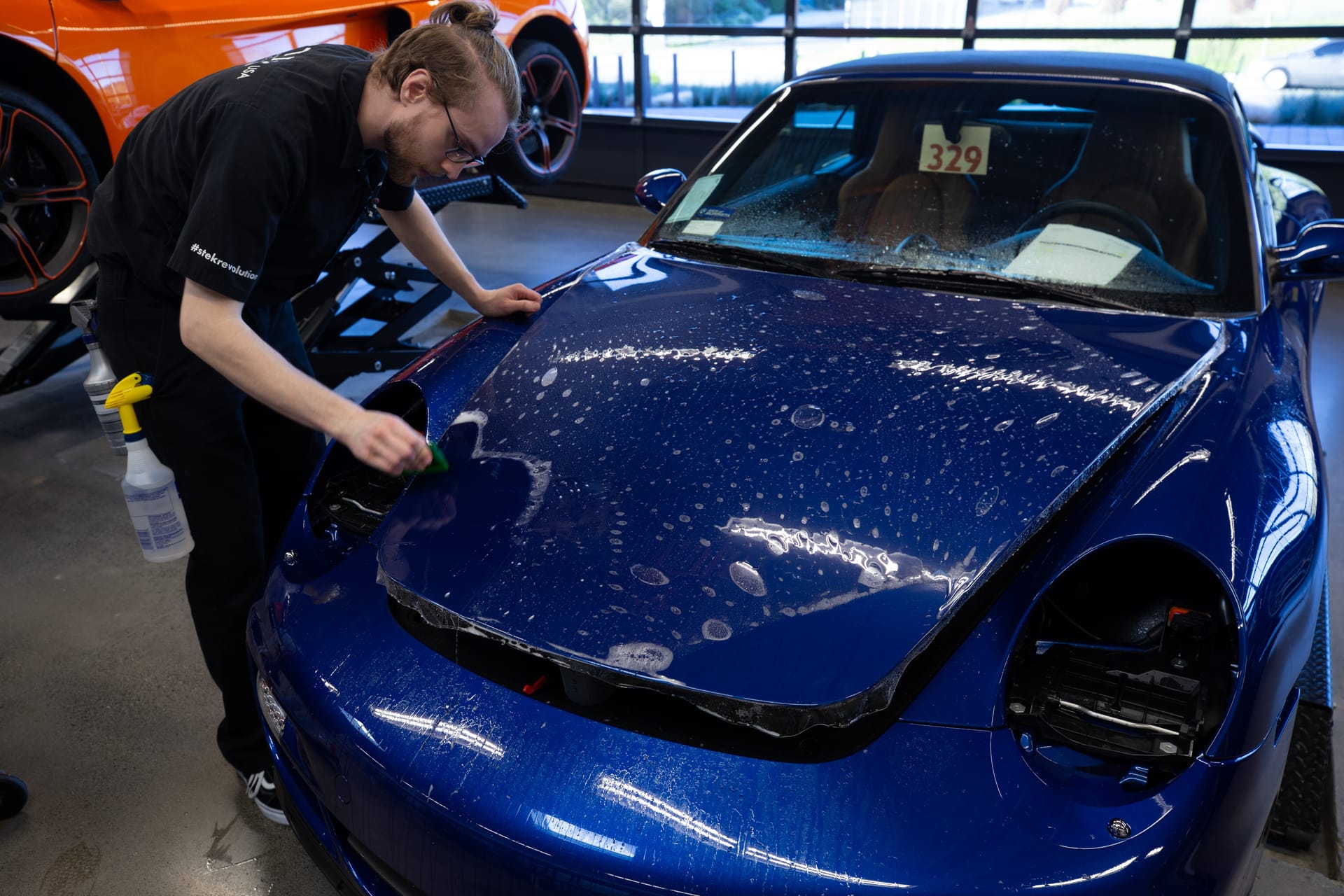 Blue Porsche 911 hood during wet PPF install.