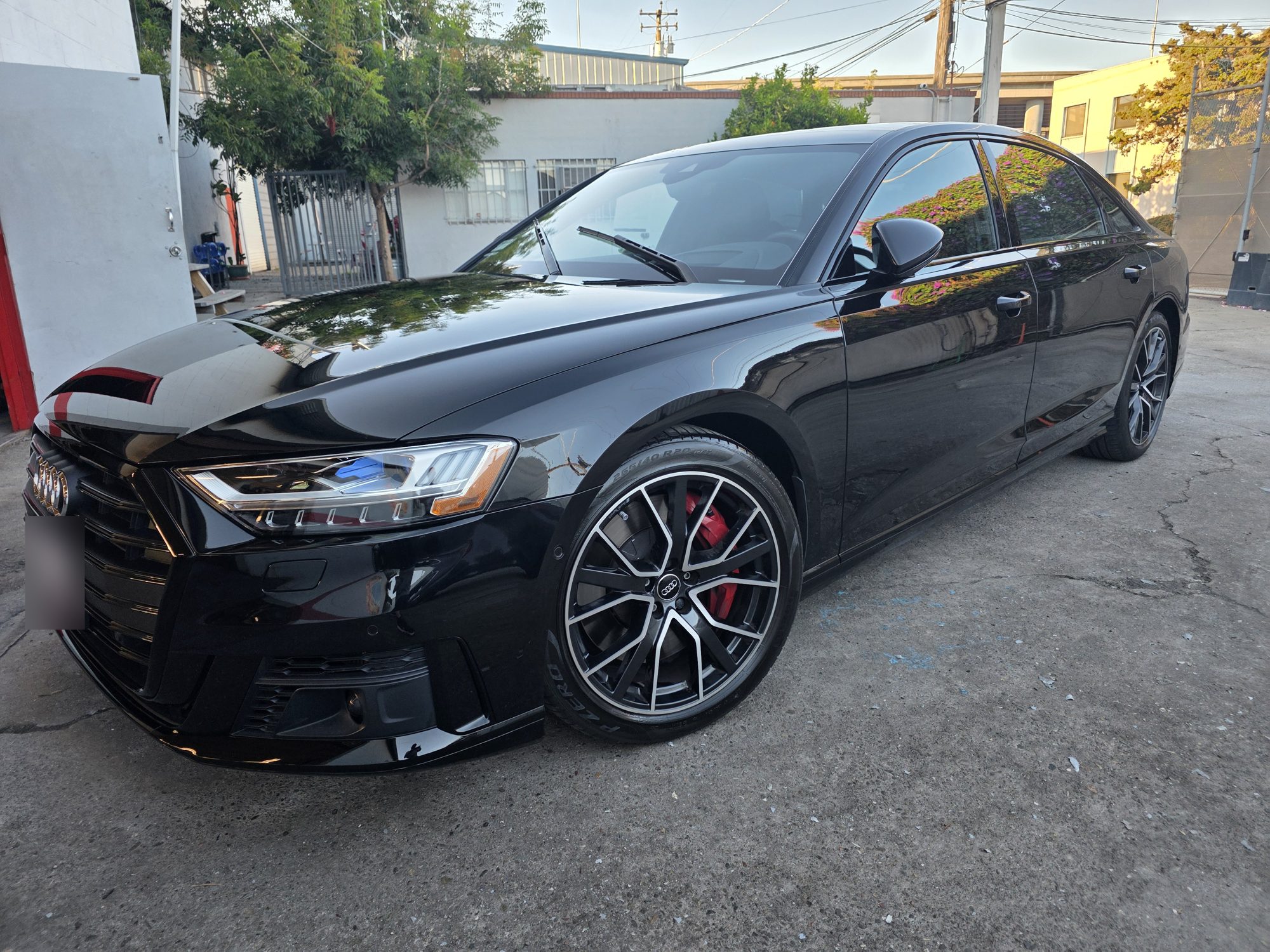 Black Audi S8 after a P&S STOUT ceramic coating, front three-quarter view outside the Innovo shop in Oakland.