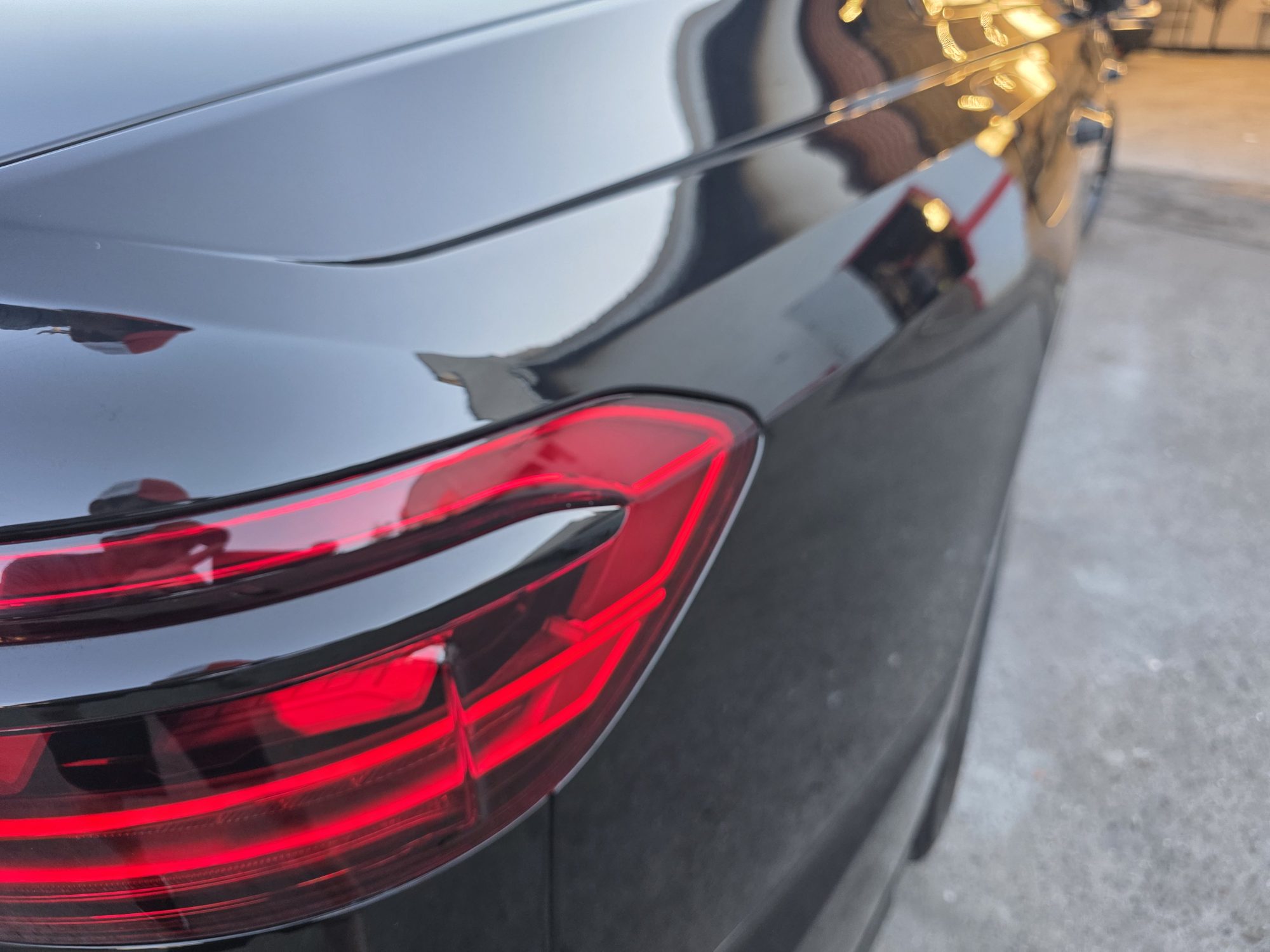 Tail light and rear quarter detail on a ceramic-coated black Audi S8, reflections unbroken across the panel.
