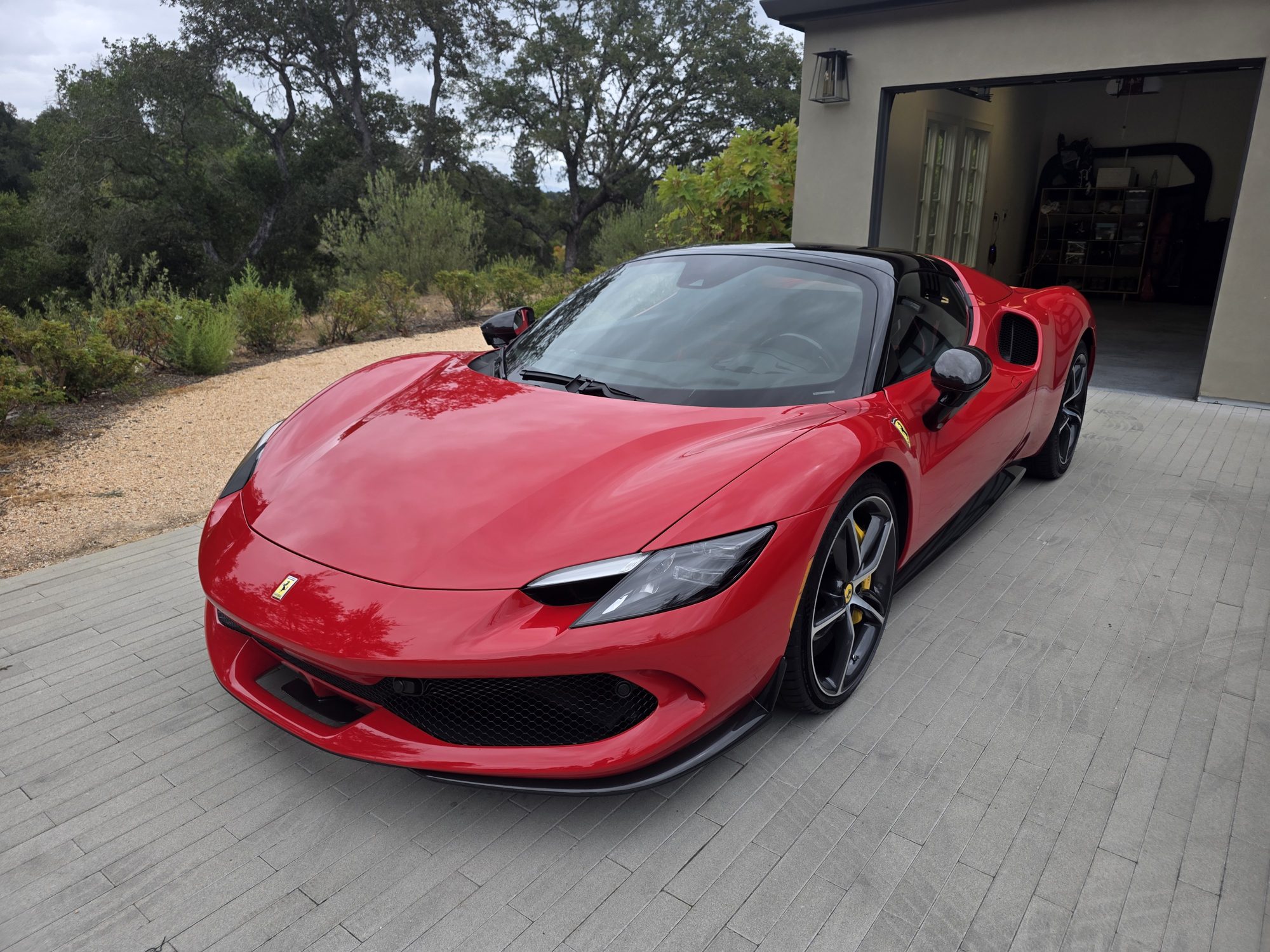 Red Ferrari 296 GTS after a P&S STOUT ceramic coating, front three-quarter view on the owner's driveway; a mobile Innovo job.
