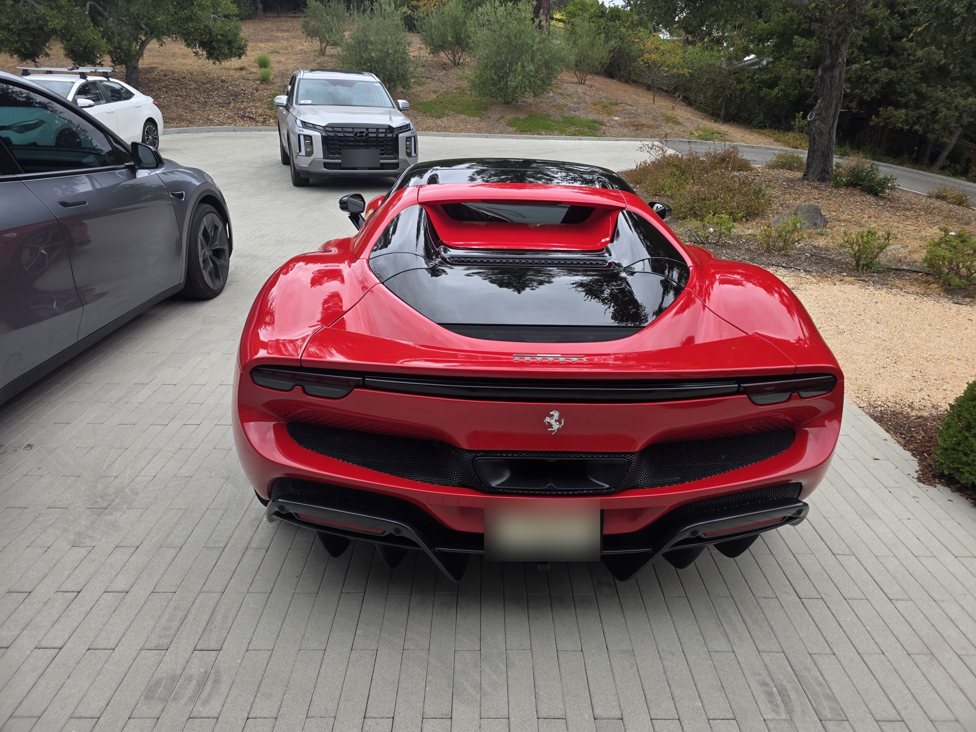 Straight-on rear view of a ceramic-coated red Ferrari 296 GTS, diffuser and rear deck.