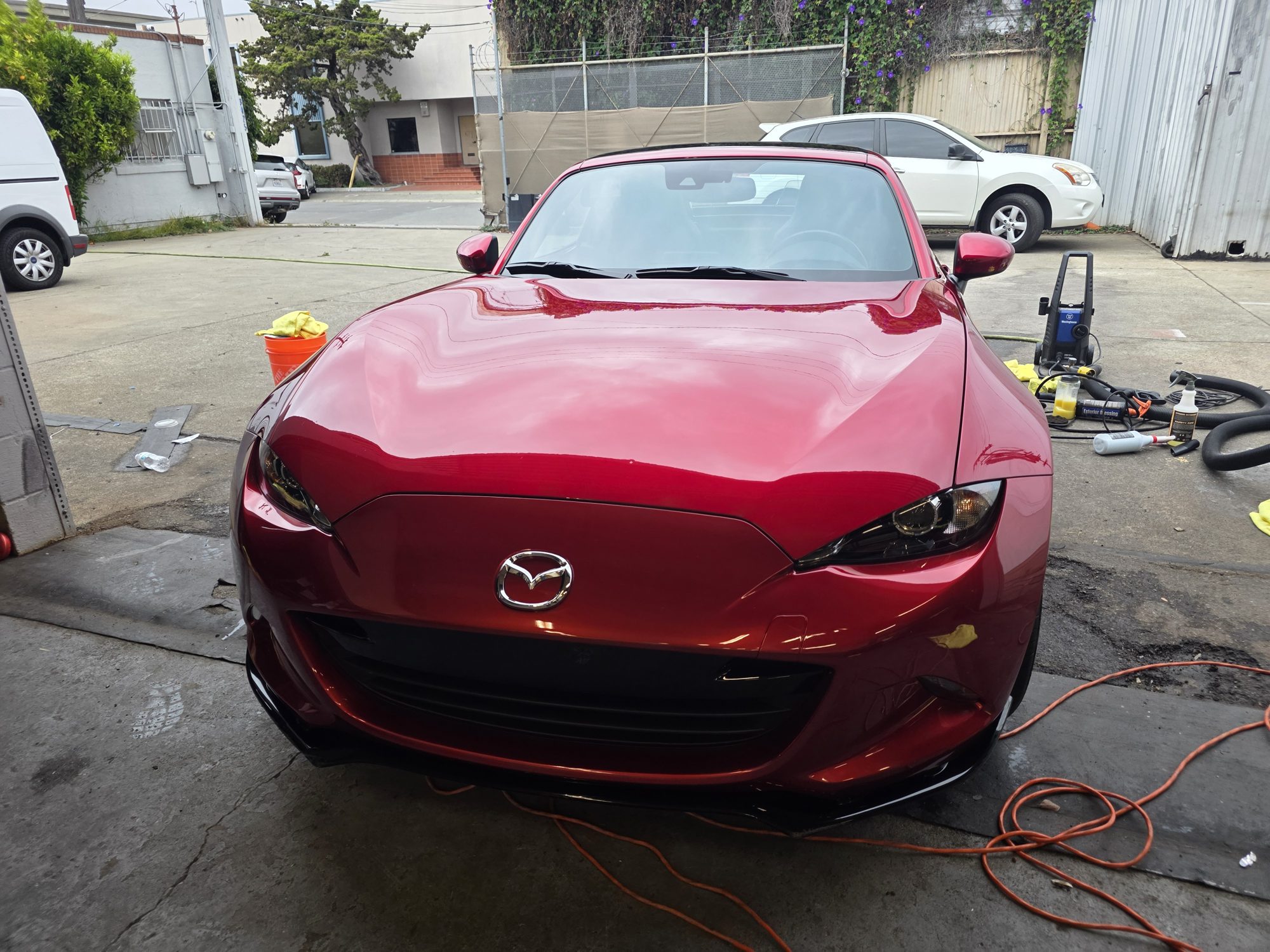 Red Mazda MX-5 RF after a P&S STOUT ceramic coating, straight-on front view at the Innovo shop in Oakland.