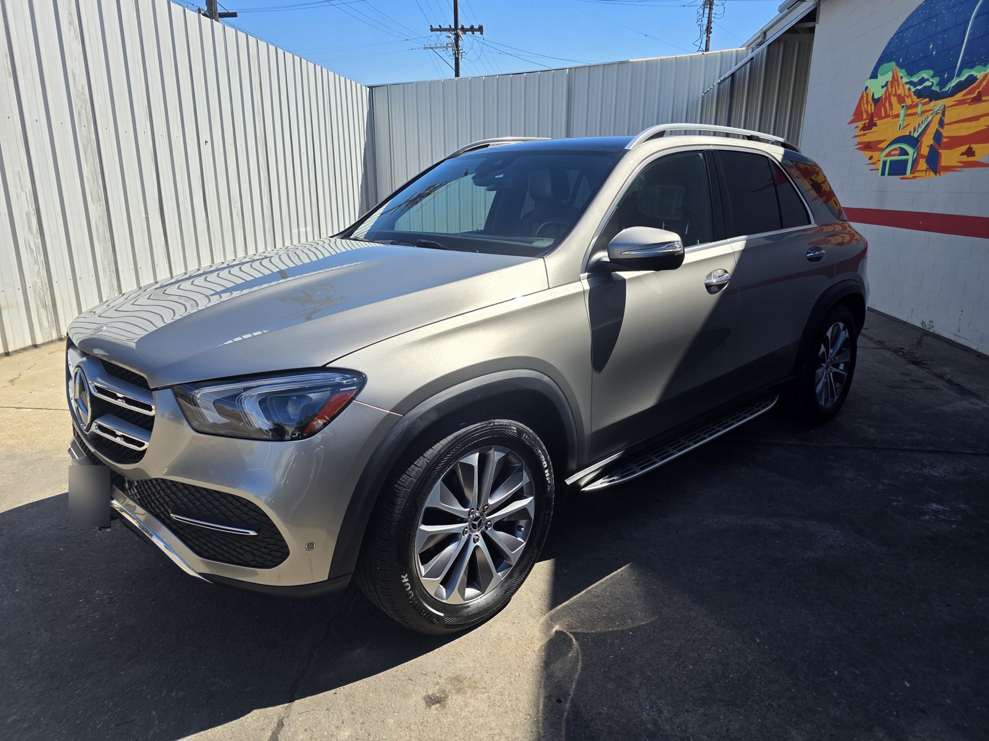 Silver Mercedes-Benz GLE after a P&S STOUT ceramic coating, front three-quarter view in the sun outside the Innovo shop.