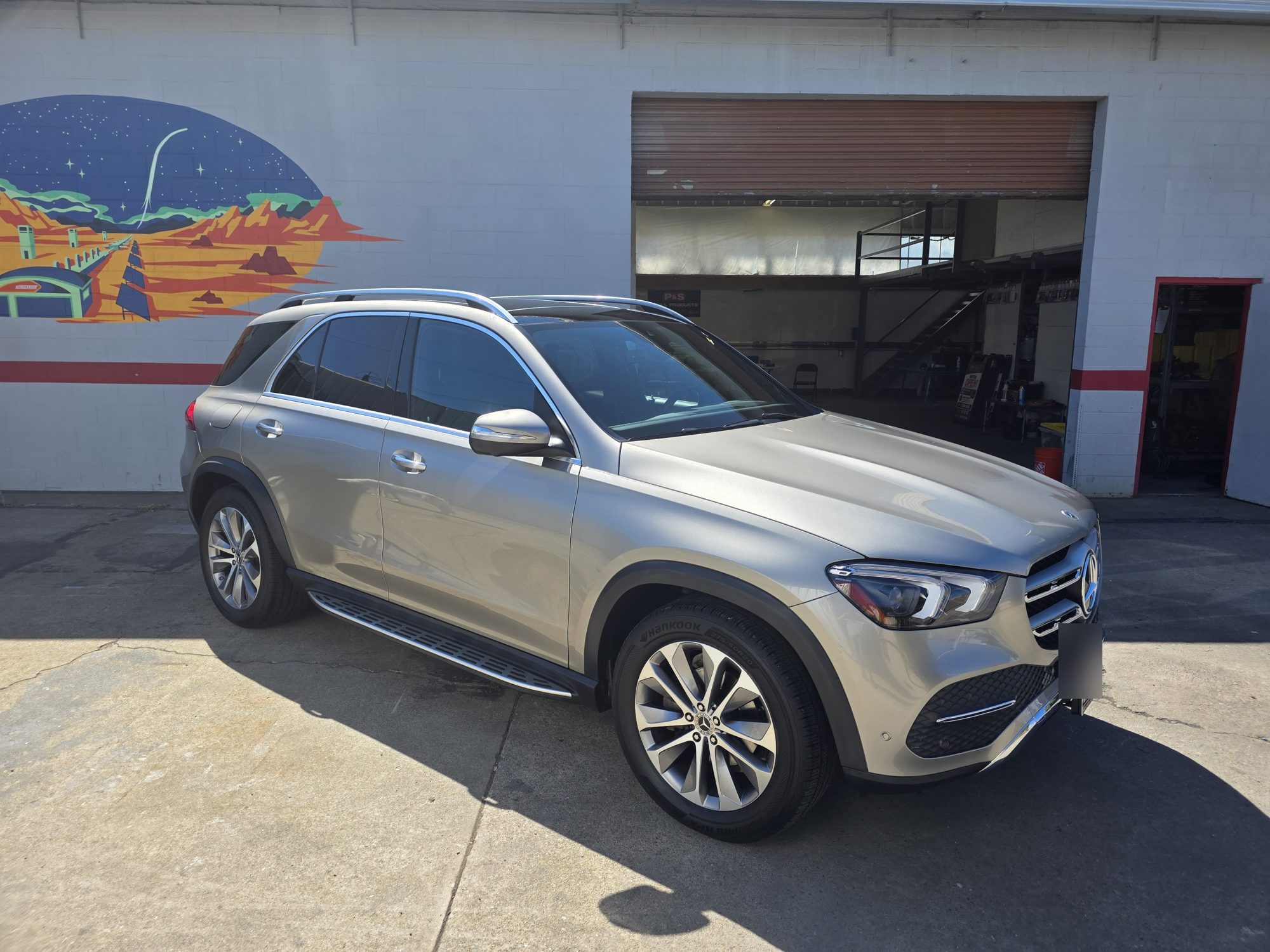 Front three-quarter view of a silver Mercedes-Benz GLE after a P&S STOUT ceramic coating at the Innovo shop door.