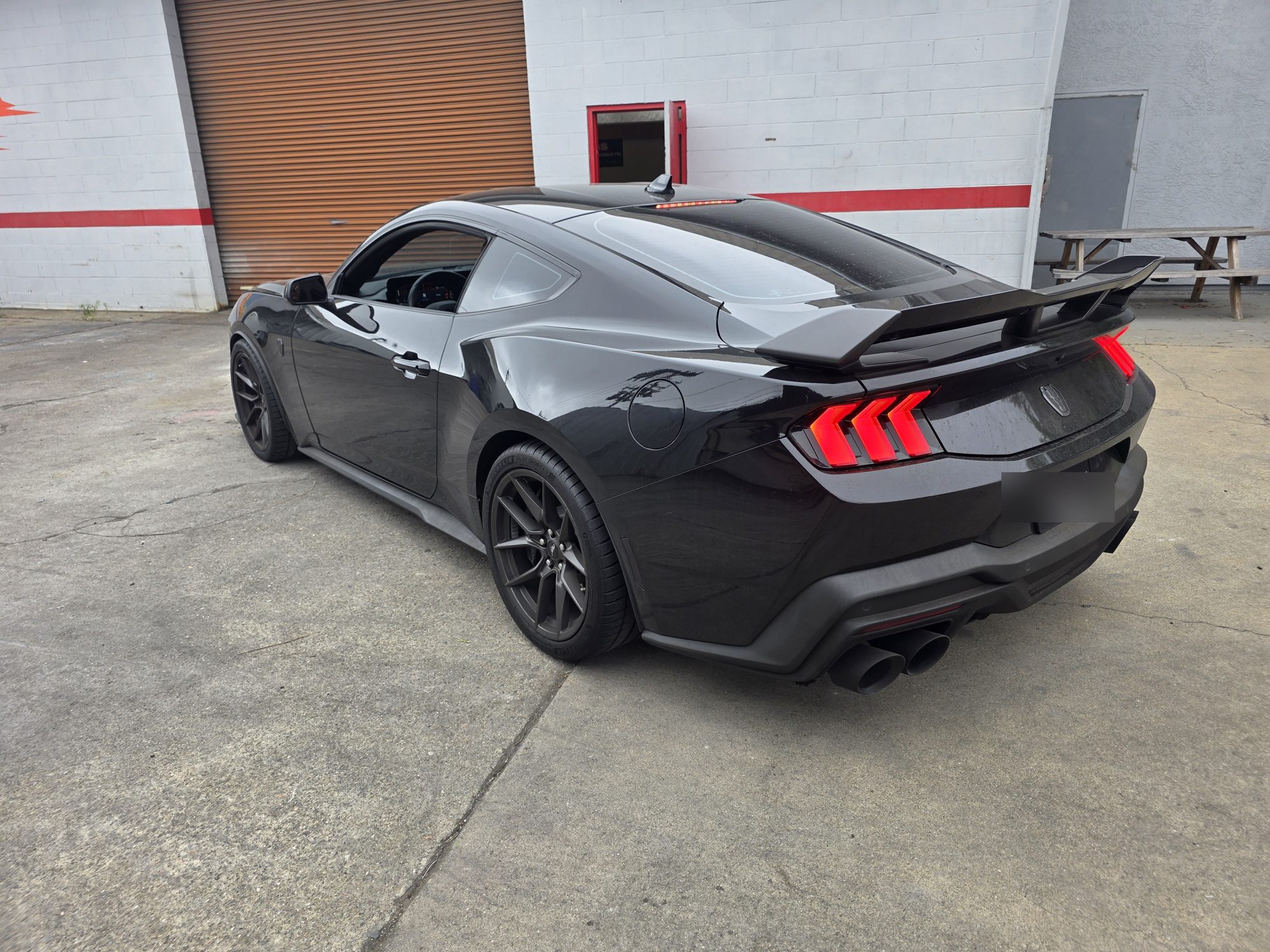 Driver-side rear three-quarter view of a black Mustang Dark Horse after a P&S STOUT ceramic coating at the Innovo shop.