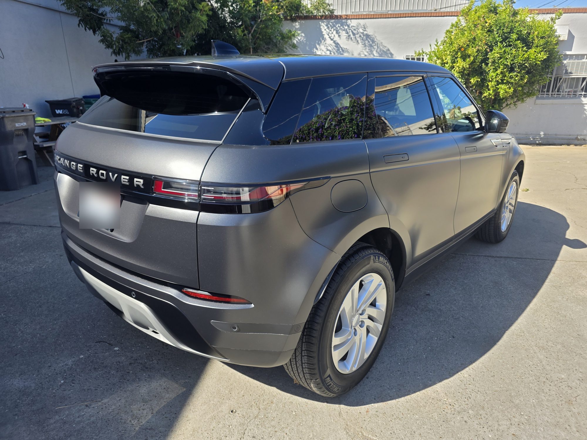 Rear three-quarter view of a Range Rover Evoque wrapped in matte paint protection film, showing the uniform satin finish across the tailgate and quarter panel.