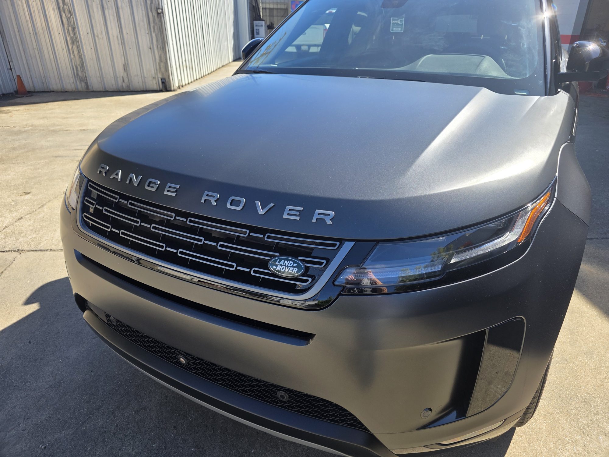 Hood and grille of a Range Rover Evoque in STEK DYNOmatte film, the matte surface meeting the gloss black grille cleanly.