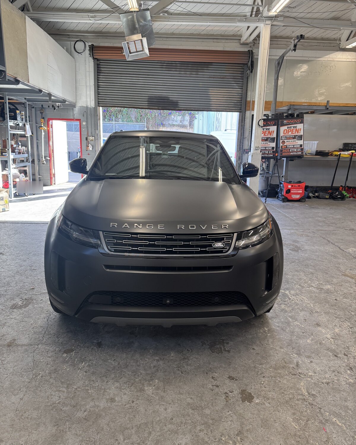 Range Rover Evoque in satin dark grey STEK DYNOmatte paint protection film, head-on in the Innovo shop doorway in Oakland.