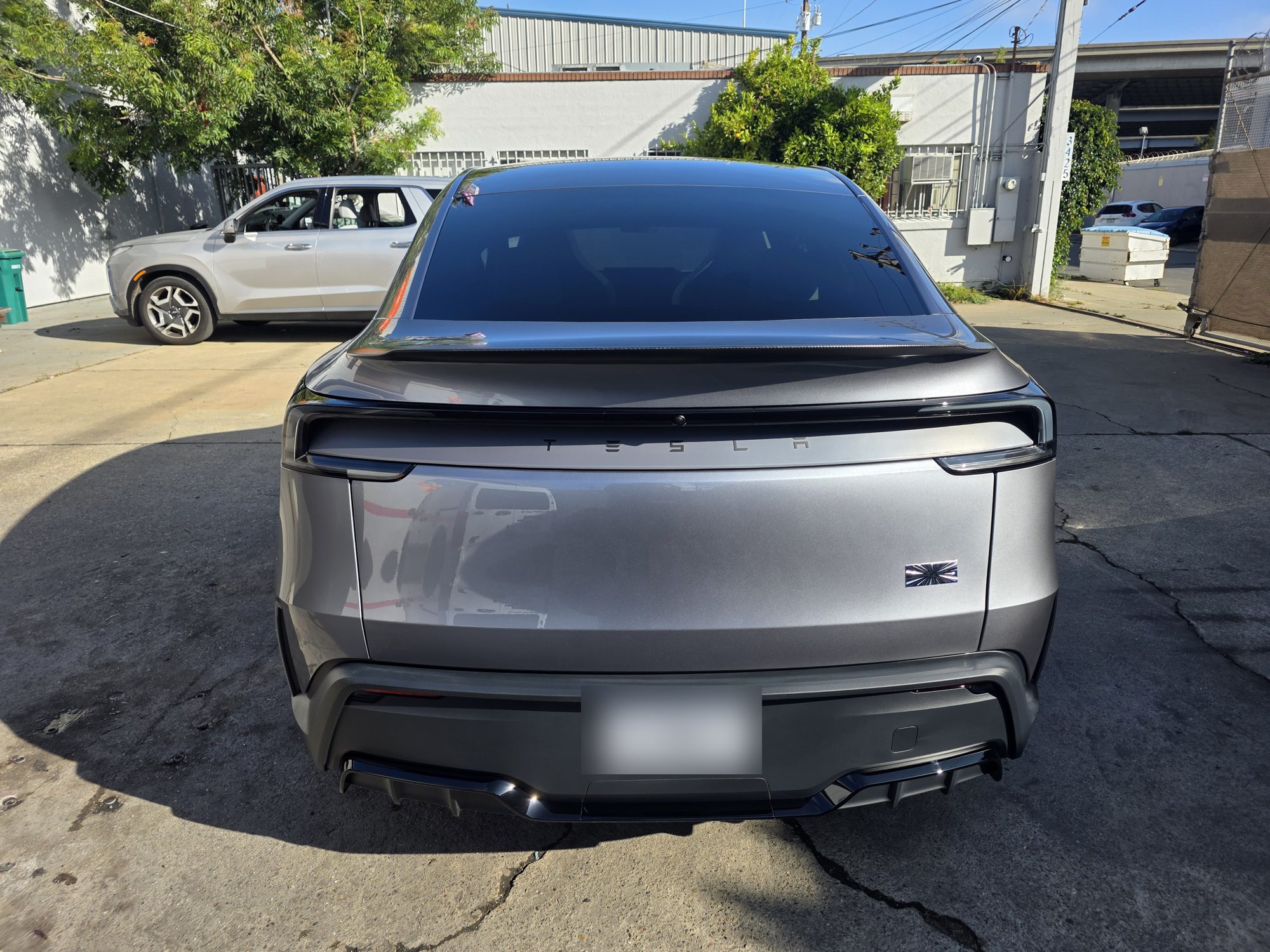 Straight-on rear view of a ceramic-coated Tesla Model Y outside the Innovo shop in Oakland.