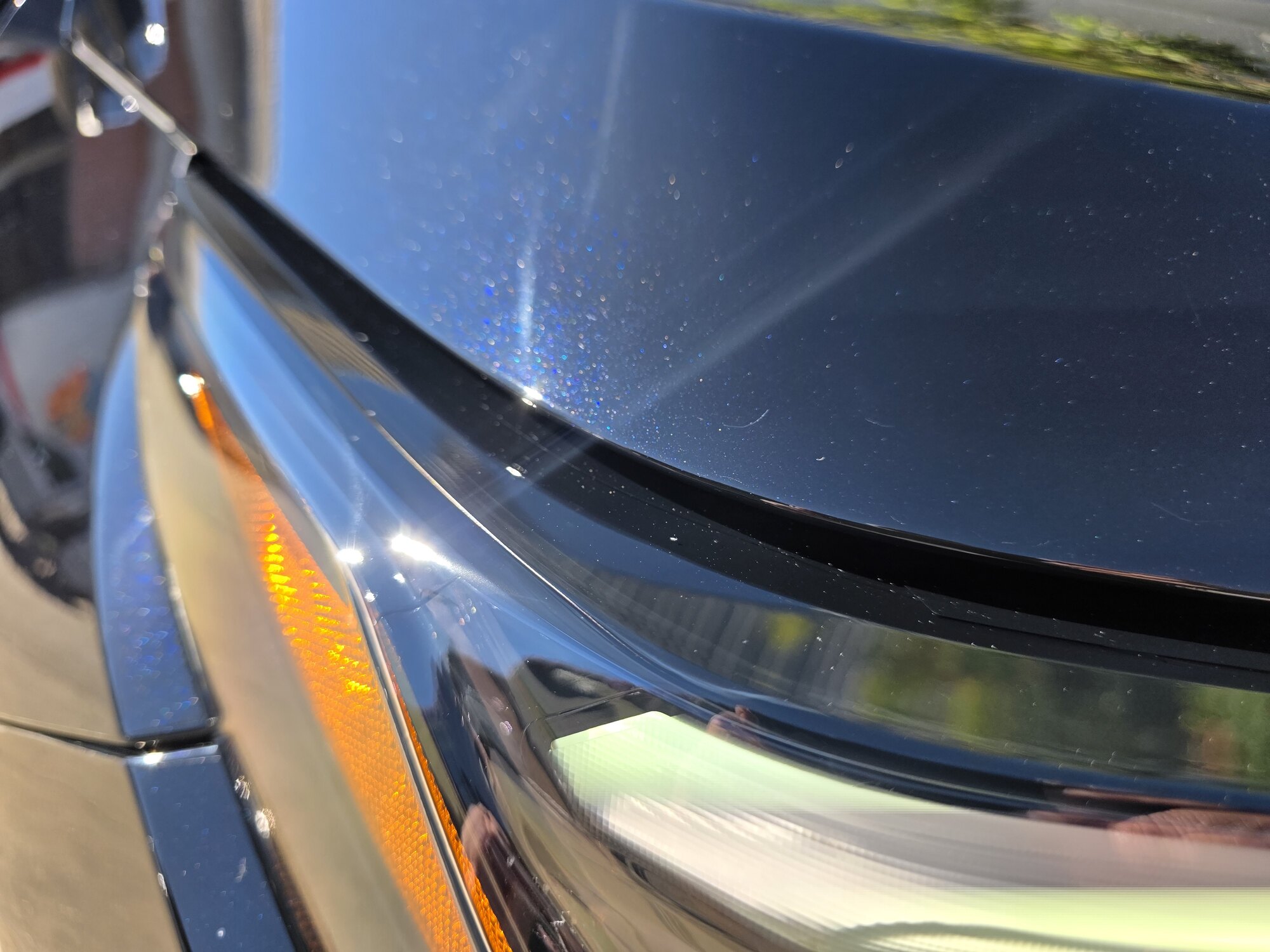 Close-up of the paint protection film edge where the fender meets the turn signal on a dark blue 2026 Toyota RAV4.